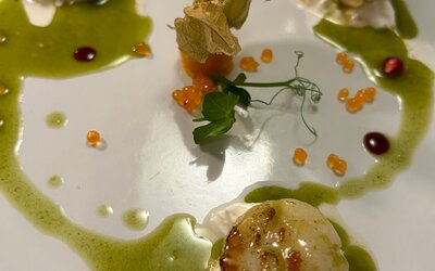 Sala interna della trattoria con tovaglie bianche e luce calda
