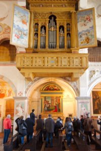 Chiesa di San Nicola, visita guidata davanti alla tavola dell’Annunciazione. In alto, il monumentale organo Antegnati del 1588